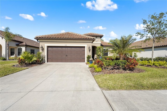 mediterranean / spanish house with concrete driveway, an attached garage, a tile roof, and stucco siding