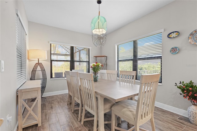 dining area with a chandelier, plenty of natural light, and wood-type flooring