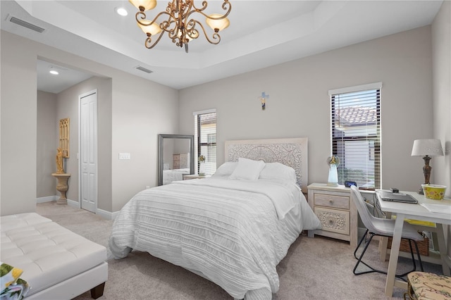 bedroom with a raised ceiling, a closet, light colored carpet, and an inviting chandelier