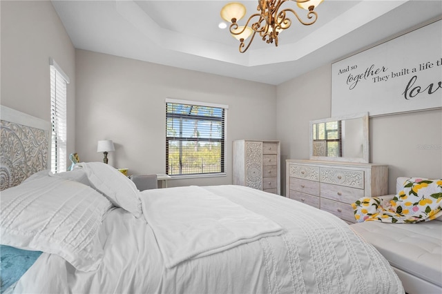 bedroom with a chandelier and a raised ceiling