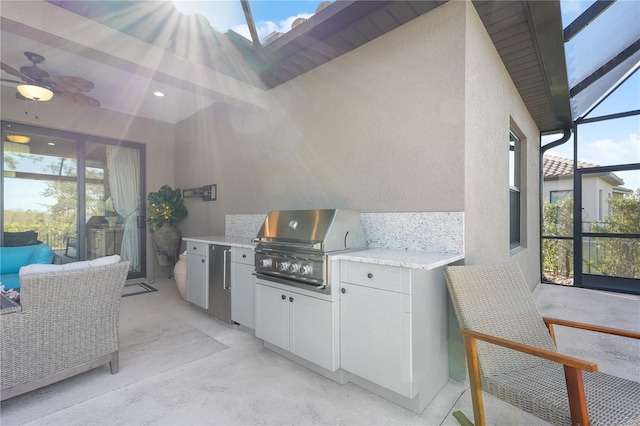 view of patio / terrace featuring ceiling fan, a lanai, exterior kitchen, and grilling area