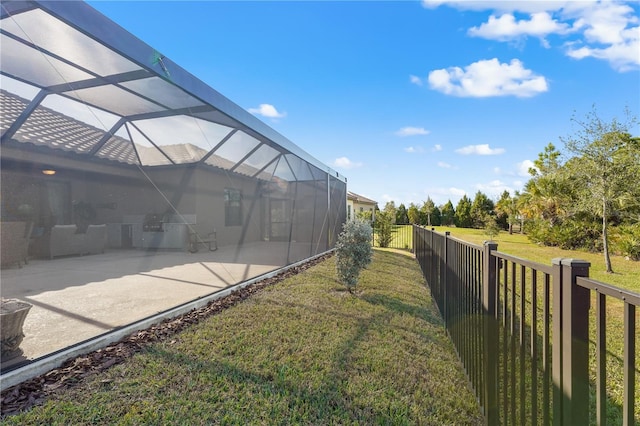 view of yard with glass enclosure and a patio area