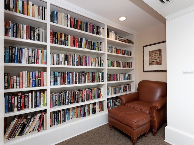 sitting room with dark carpet and ornamental molding