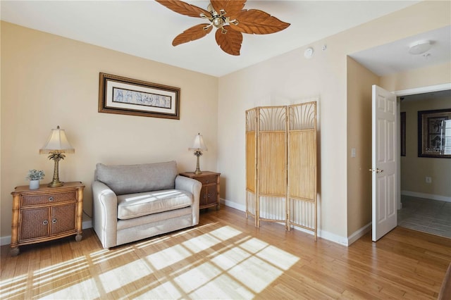 living area featuring wood-type flooring and ceiling fan