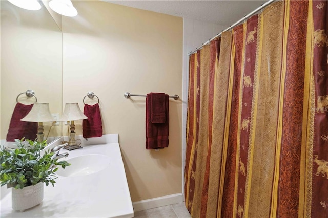 bathroom featuring tile patterned flooring, sink, and a textured ceiling