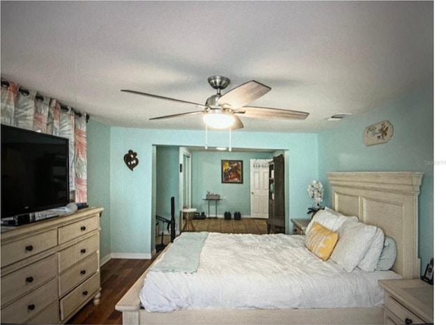 bedroom with dark hardwood / wood-style flooring and ceiling fan