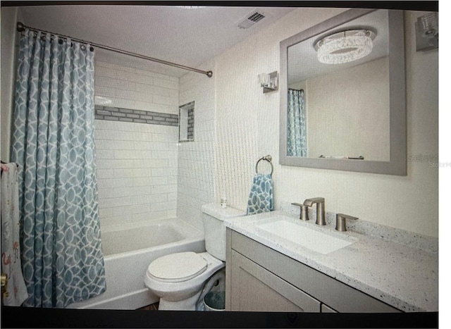 full bathroom featuring a textured ceiling, vanity, toilet, and shower / bathtub combination with curtain