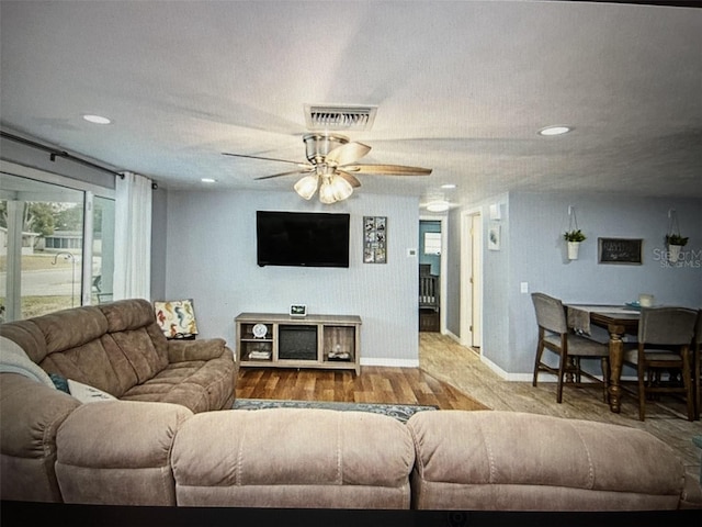 living room featuring ceiling fan and hardwood / wood-style floors