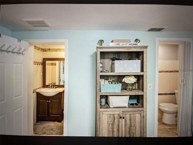 bathroom with tile patterned flooring, vanity, and toilet