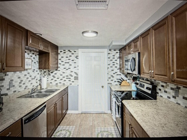 kitchen featuring stainless steel appliances, tasteful backsplash, and sink