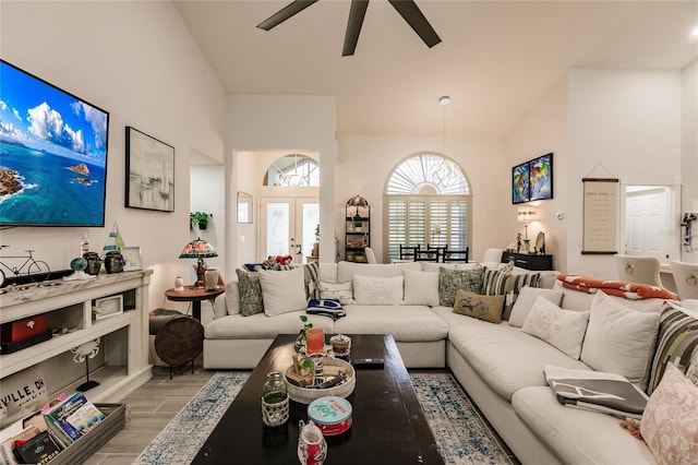 living room with french doors, light hardwood / wood-style floors, high vaulted ceiling, and ceiling fan