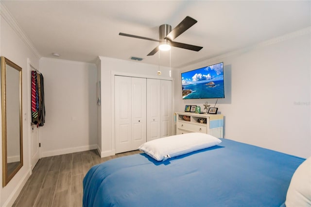 bedroom featuring ceiling fan, a closet, ornamental molding, and light wood-type flooring