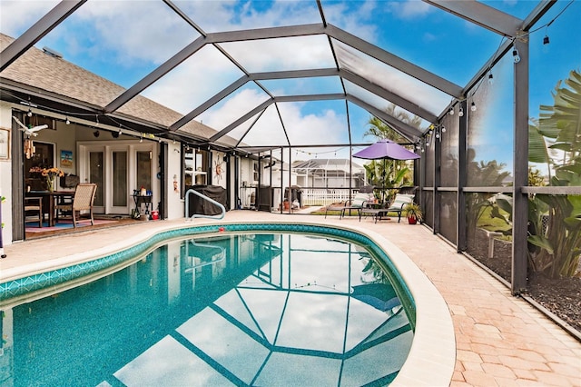 view of swimming pool with a patio area and glass enclosure