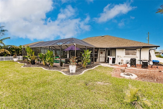 back of property featuring a lanai and a lawn