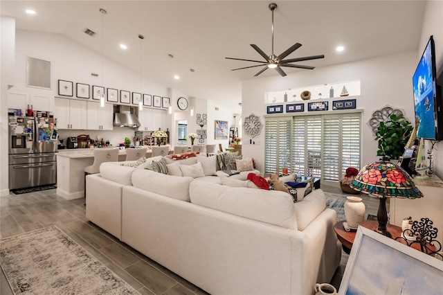 living room with ceiling fan, light wood-type flooring, and high vaulted ceiling