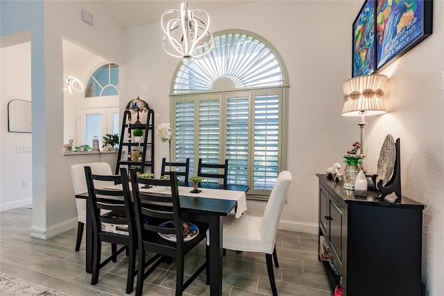 dining area with hardwood / wood-style floors, a wealth of natural light, and a chandelier