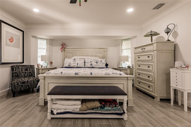 bedroom featuring light hardwood / wood-style flooring and crown molding