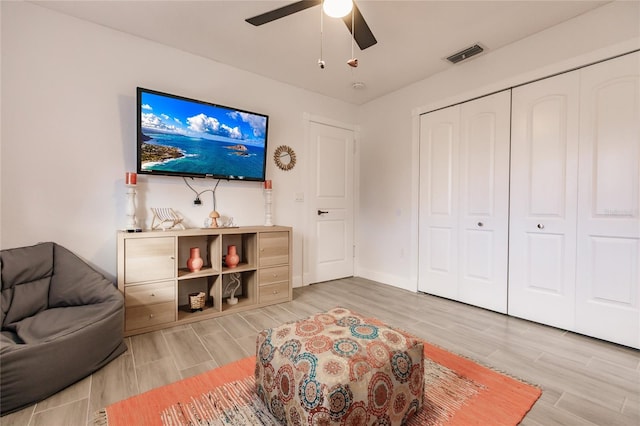 living room featuring wood-type flooring and ceiling fan