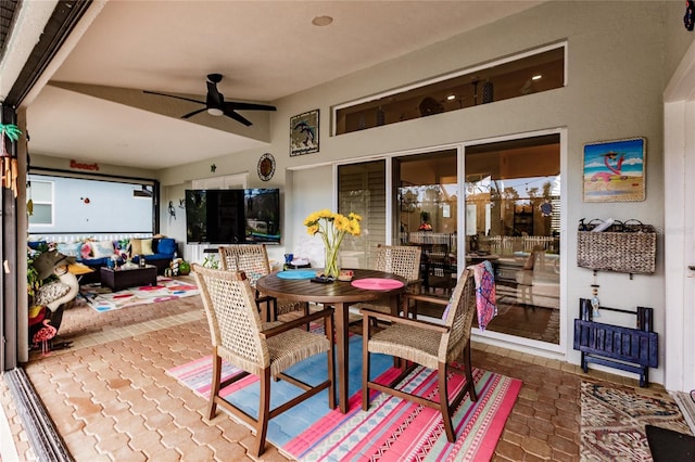 sunroom with ceiling fan and beam ceiling