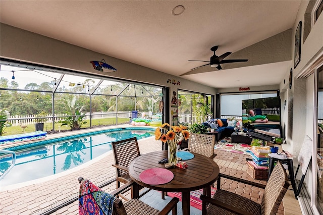 view of swimming pool featuring an outdoor living space, ceiling fan, a patio, and glass enclosure