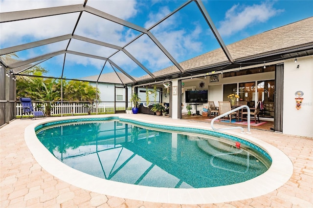 view of swimming pool featuring a patio area and a lanai