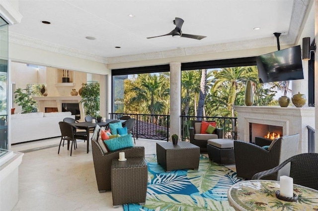 sunroom / solarium with ceiling fan and an outdoor fireplace