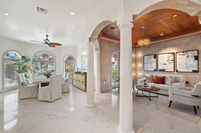 dining area featuring decorative columns and ceiling fan with notable chandelier