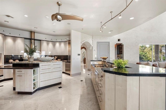 kitchen with backsplash, sink, and a spacious island