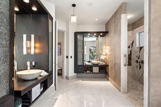 bathroom with a tile shower and vanity