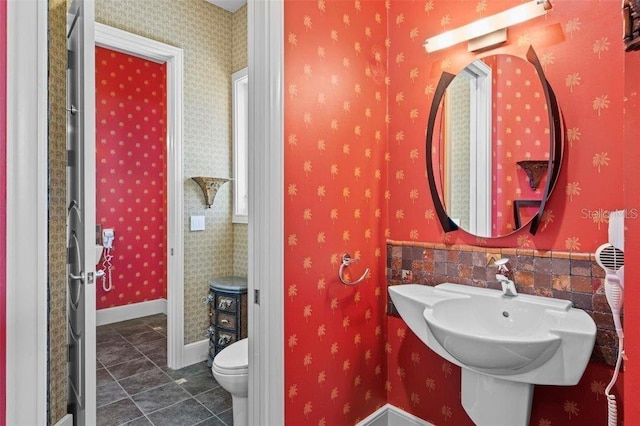 bathroom featuring tile patterned flooring, toilet, and sink