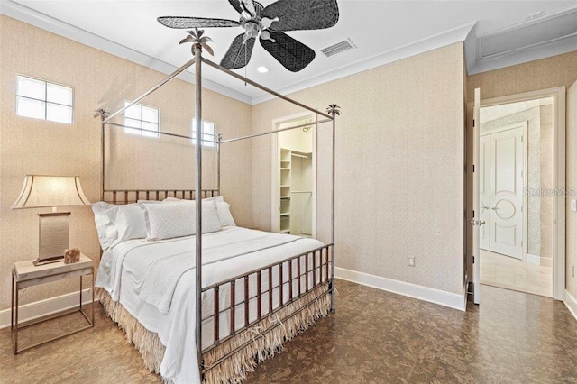 bedroom featuring a closet, a spacious closet, ceiling fan, and crown molding