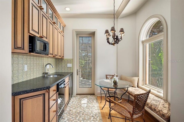 kitchen with sink, an inviting chandelier, backsplash, light hardwood / wood-style floors, and decorative light fixtures