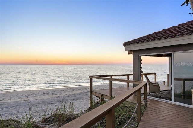 view of dock featuring a water view and a view of the beach