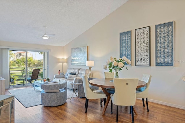 dining space with hardwood / wood-style flooring, vaulted ceiling, and ceiling fan