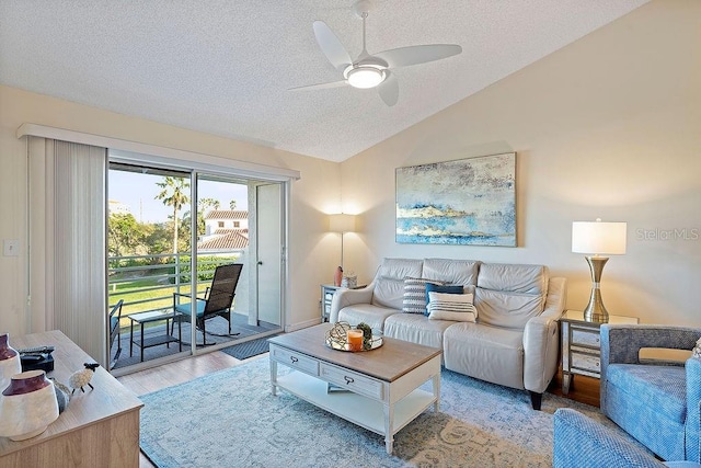 living room featuring vaulted ceiling, a textured ceiling, and ceiling fan