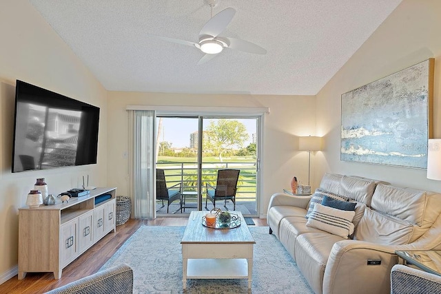 living room with a textured ceiling, vaulted ceiling, and wood-type flooring