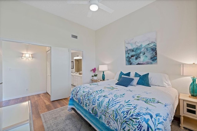 bedroom with ensuite bath, light hardwood / wood-style flooring, and ceiling fan