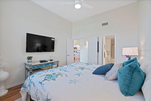 bedroom with hardwood / wood-style floors, a high ceiling, ceiling fan, and ensuite bathroom