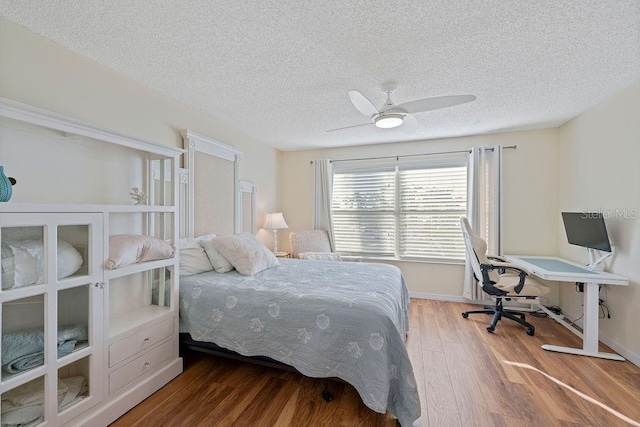 bedroom with wood-type flooring, a textured ceiling, and ceiling fan