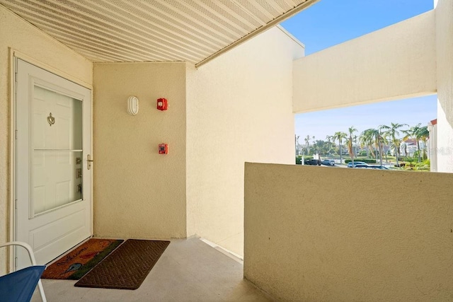 property entrance featuring a balcony and stucco siding