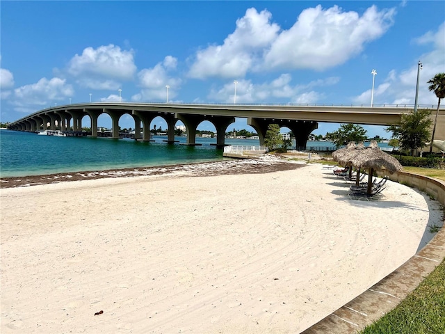 view of home's community featuring a water view and a beach view