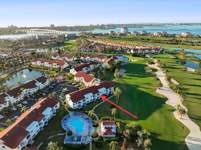 drone / aerial view with a water view and golf course view