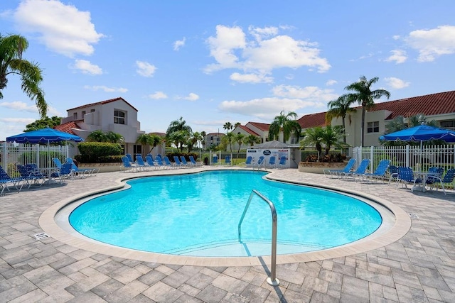 community pool with fence and a patio