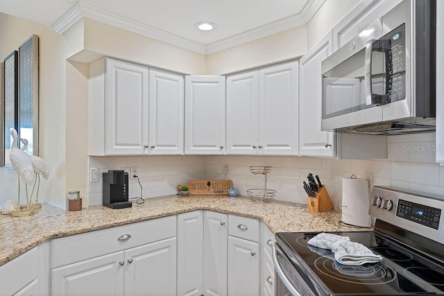 kitchen featuring ornamental molding, appliances with stainless steel finishes, white cabinetry, and light stone countertops