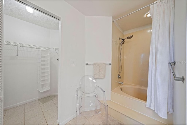 full bathroom featuring shower / bath combo with shower curtain, a spacious closet, baseboards, and tile patterned floors