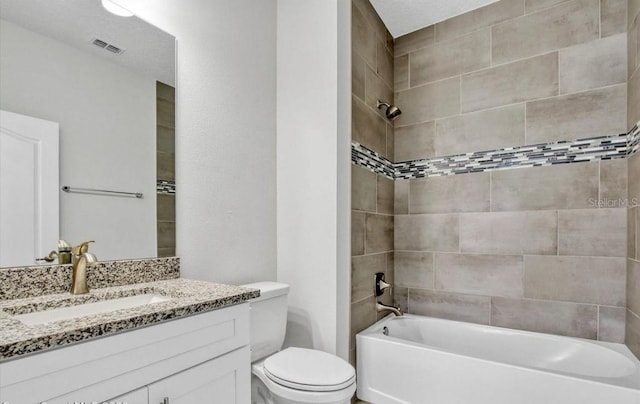 full bathroom with a textured ceiling, vanity, tiled shower / bath combo, and toilet