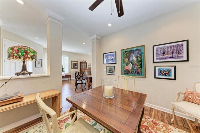 dining room featuring hardwood / wood-style flooring, decorative columns, and ceiling fan