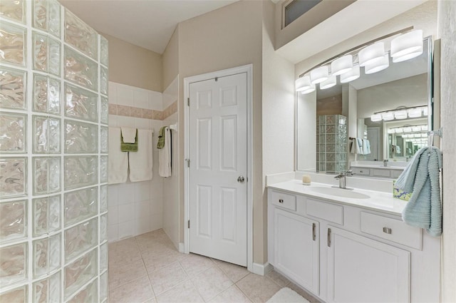 bathroom with tile patterned flooring, a shower, and vanity