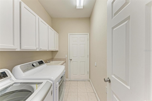 laundry area featuring washer and clothes dryer, light tile patterned floors, cabinets, and sink