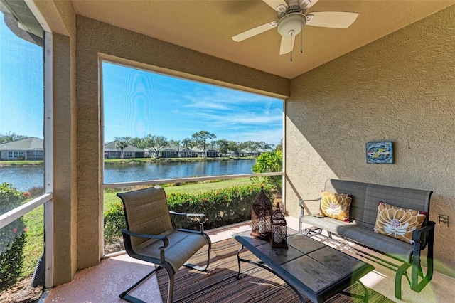 sunroom / solarium with ceiling fan, a healthy amount of sunlight, and a water view